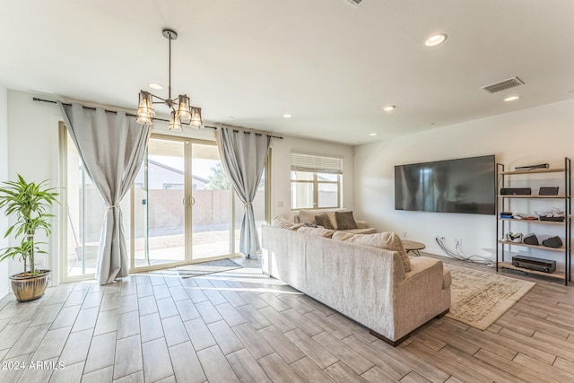 unfurnished living room featuring a chandelier and light hardwood / wood-style flooring