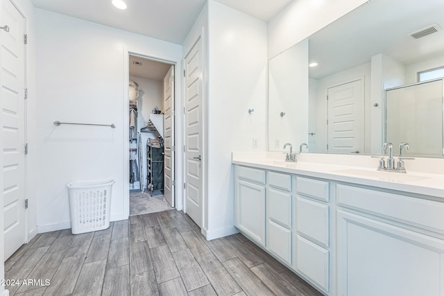 bathroom with vanity, hardwood / wood-style flooring, and a shower with shower door