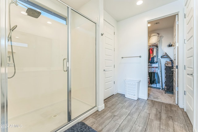 bathroom featuring hardwood / wood-style floors and a shower with shower door