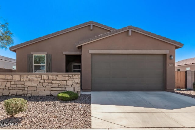 ranch-style home featuring concrete driveway, an attached garage, fence, and stucco siding