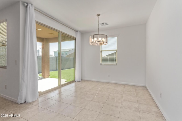 spare room with a chandelier, plenty of natural light, visible vents, and baseboards