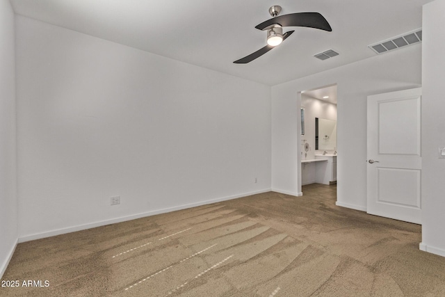 unfurnished bedroom with carpet floors, ensuite bath, visible vents, and baseboards