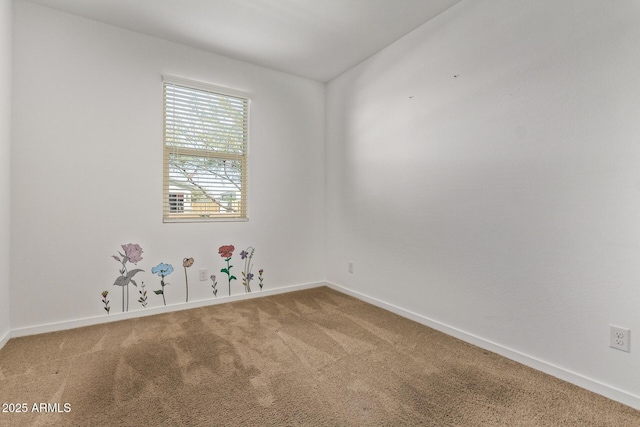 spare room featuring carpet flooring and baseboards