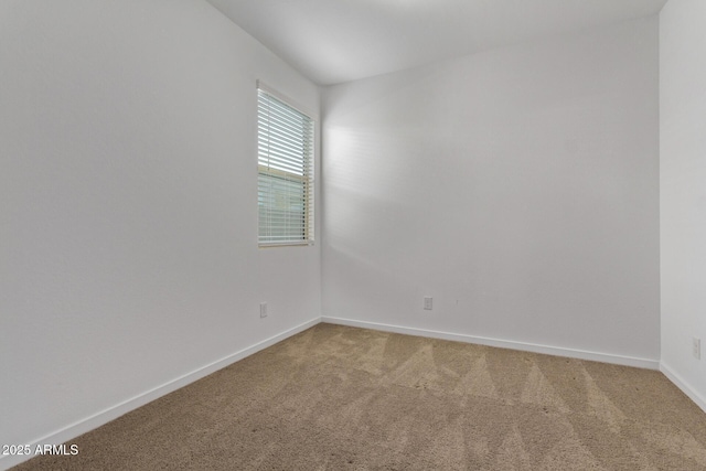 spare room with light carpet and baseboards