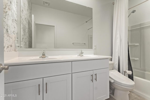 bathroom featuring toilet, double vanity, a sink, and visible vents