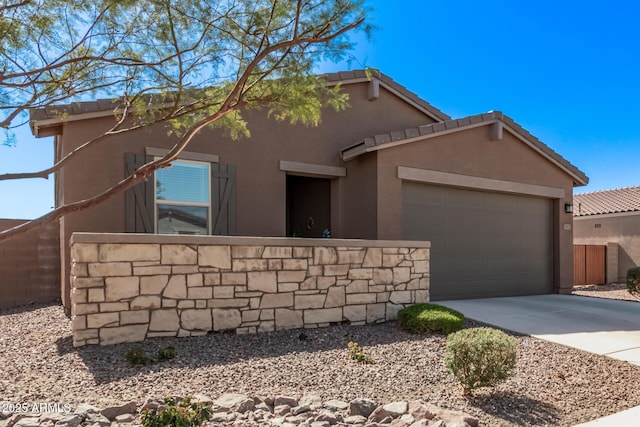 view of front of house featuring concrete driveway, a tile roof, an attached garage, fence, and stucco siding