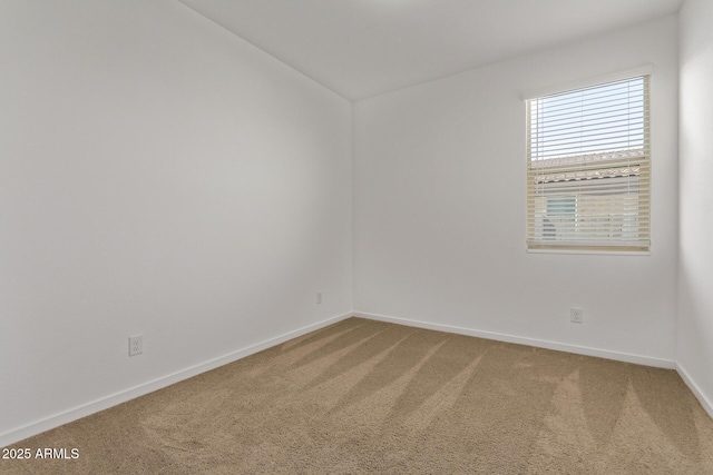 carpeted empty room featuring baseboards