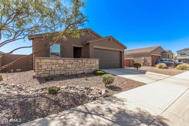 view of front of home with stucco siding, fence, a garage, driveway, and a tiled roof