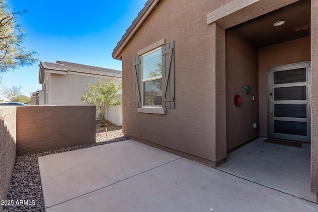 view of home's exterior featuring a patio, fence, and stucco siding