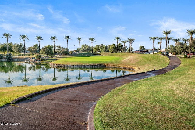 surrounding community featuring a lawn and a water view