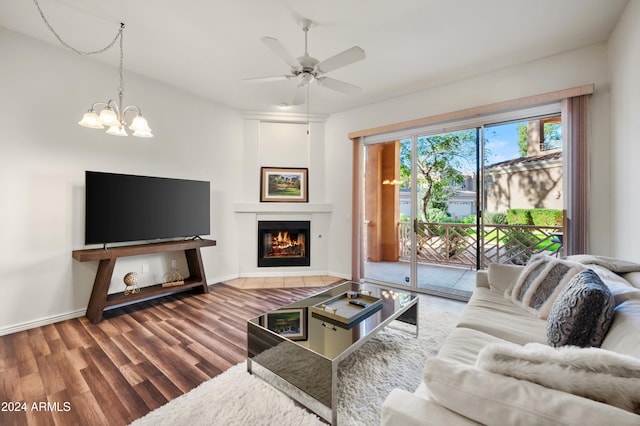 living room with ceiling fan with notable chandelier and wood-type flooring