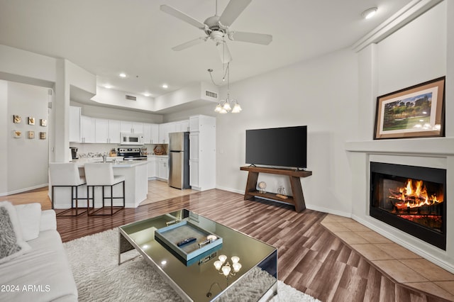 living room with light hardwood / wood-style flooring and ceiling fan