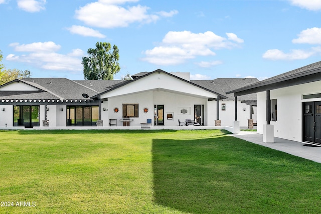 rear view of property featuring a yard and a patio area