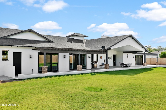 rear view of property with a patio and a yard