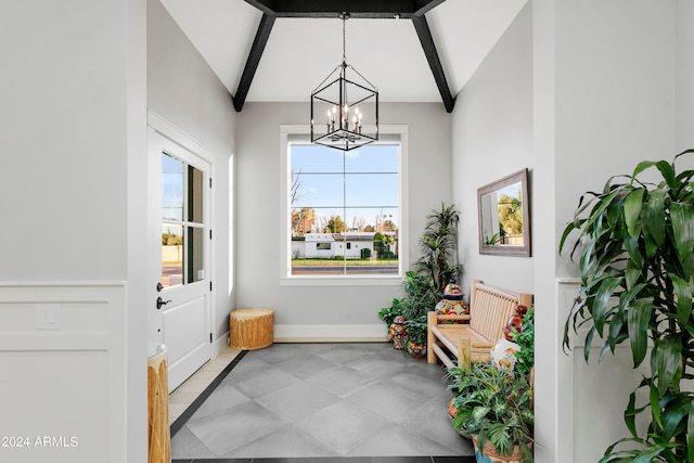 entryway with a notable chandelier and vaulted ceiling with beams