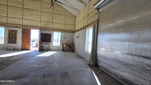 interior space with a healthy amount of sunlight, lofted ceiling, and concrete flooring