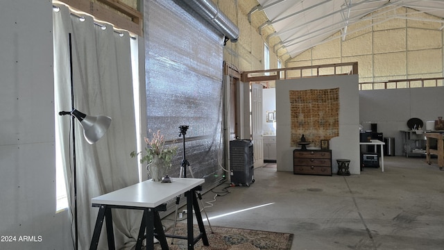 misc room featuring lofted ceiling and concrete floors