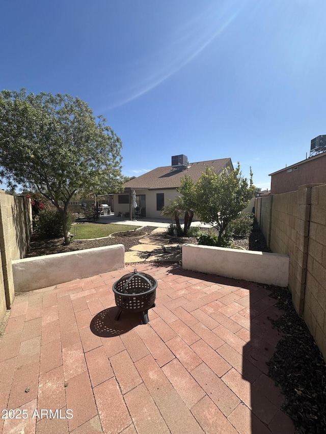 view of patio with fence, central AC, and an outdoor fire pit