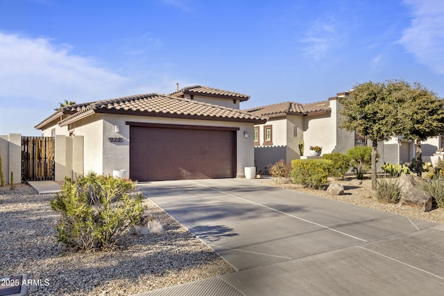 view of front facade with a garage, driveway, a tiled roof, and stucco siding