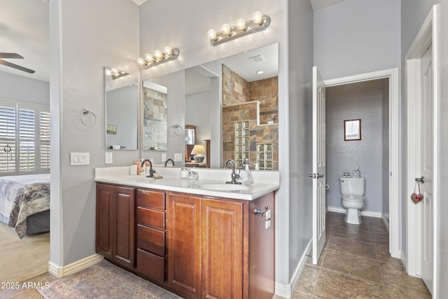 full bath with a sink, a ceiling fan, baseboards, double vanity, and ensuite bath