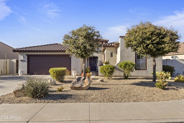 view of front facade featuring a garage, concrete driveway, a tiled roof, and stucco siding