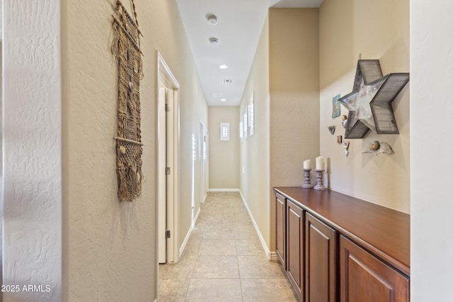 corridor featuring light tile patterned floors, baseboards, and recessed lighting