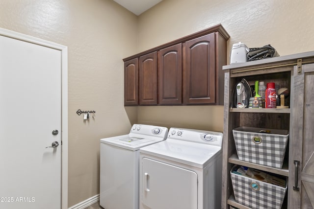 laundry room with a textured wall, independent washer and dryer, and cabinet space