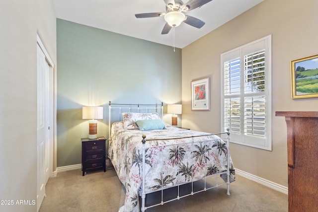 carpeted bedroom with ceiling fan, a closet, and baseboards