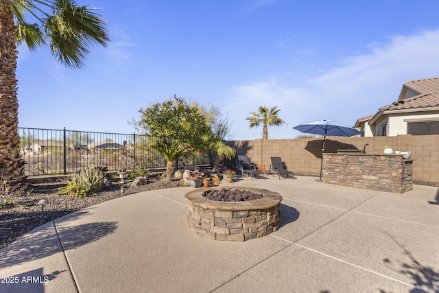 view of patio with a fenced backyard and a fire pit