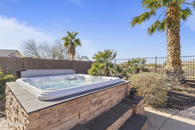 exterior space with a fenced backyard and an outdoor hot tub