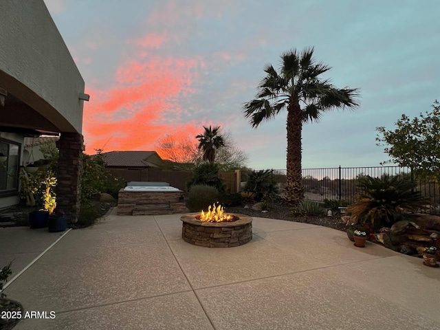 view of patio / terrace featuring an outdoor fire pit, a fenced backyard, and a jacuzzi