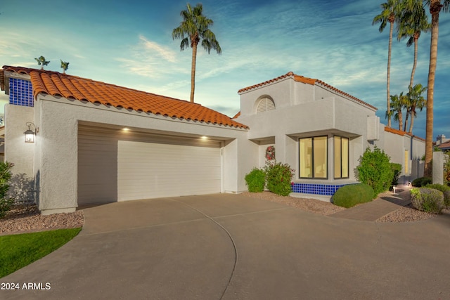 mediterranean / spanish-style home with a garage