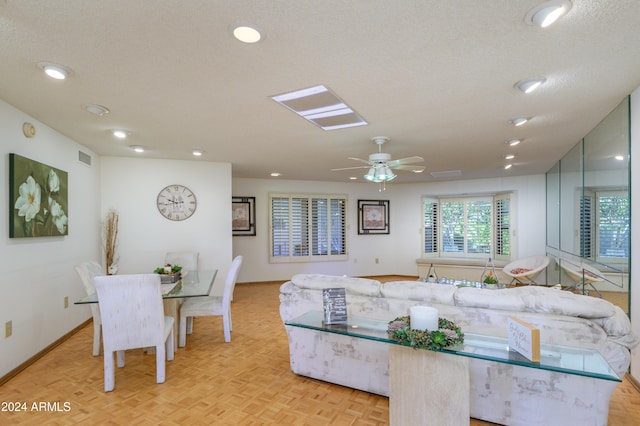 dining area with ceiling fan, a textured ceiling, and light parquet floors