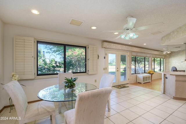 tiled dining area with french doors, ceiling fan, plenty of natural light, and a textured ceiling