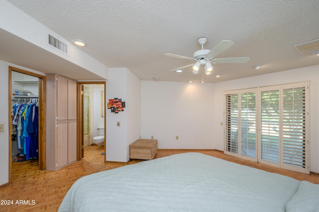 bedroom with ensuite bath, ceiling fan, a walk in closet, a closet, and light parquet flooring