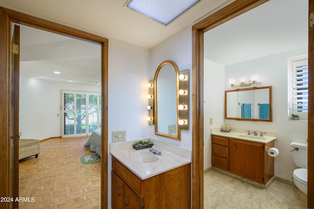 bathroom featuring vanity, toilet, and parquet floors