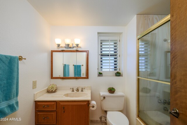 full bathroom with vanity, toilet, and enclosed tub / shower combo