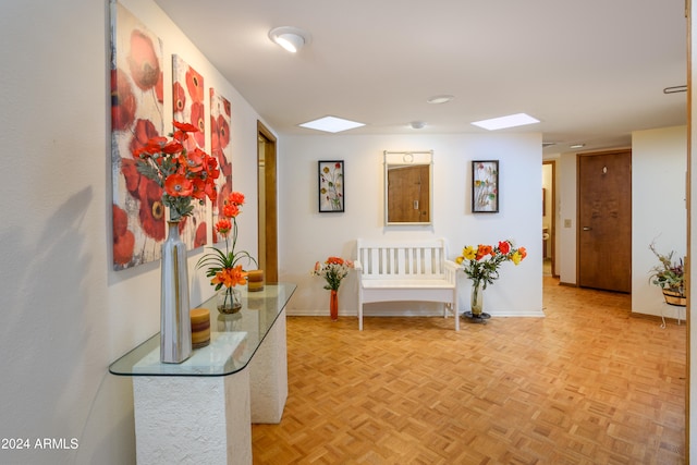 hallway with a skylight and light parquet floors