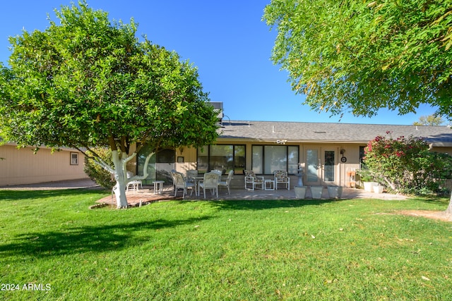 back of house with a yard and a patio