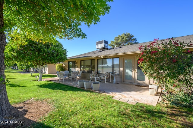 rear view of house featuring a lawn, french doors, cooling unit, an outdoor hangout area, and a patio area