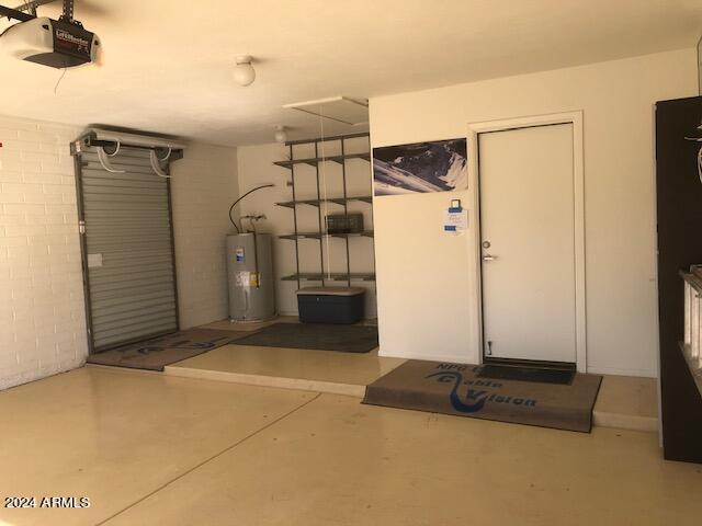 garage with electric water heater and a garage door opener