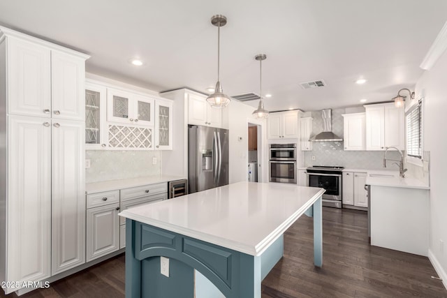 12241 N 49th Ave, Glendale, AZ 85304 - kitchen featuring appliances with stainless steel finishes, a sink, wall chimney exhaust hood, backsplash, and white cabinets