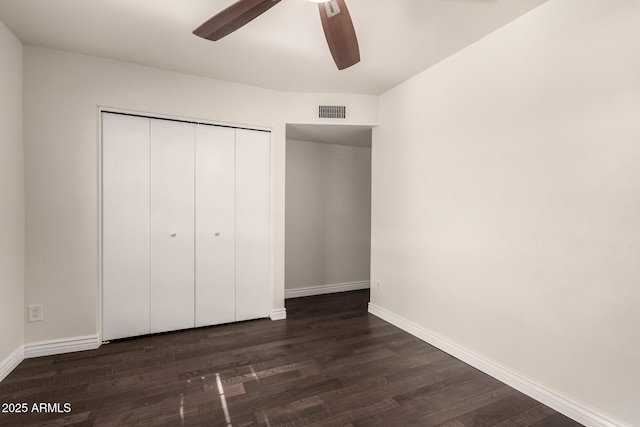 12241 N 49th Ave, Glendale, AZ 85304 - unfurnished bedroom with dark wood finished floors, baseboards, a closet, and a ceiling fan