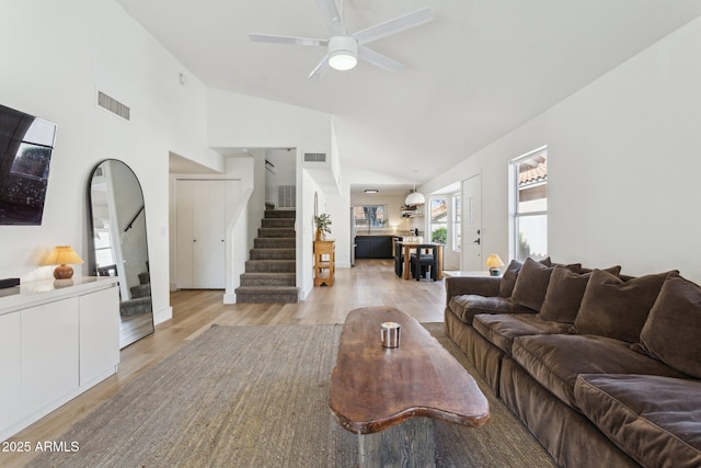 7931 W Shaw Butte Dr, Peoria, AZ 85345 - living room featuring visible vents, high vaulted ceiling, stairs, and light wood-style floors