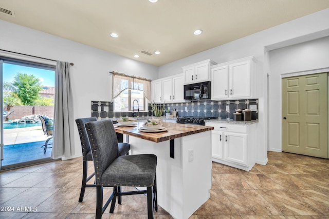 kitchen with wooden counters, white cabinetry, and light tile patterned flooring