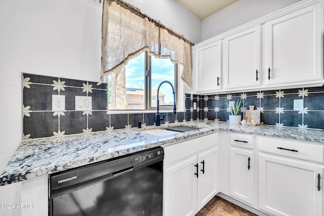 kitchen featuring black dishwasher, tasteful backsplash, sink, light stone countertops, and white cabinetry