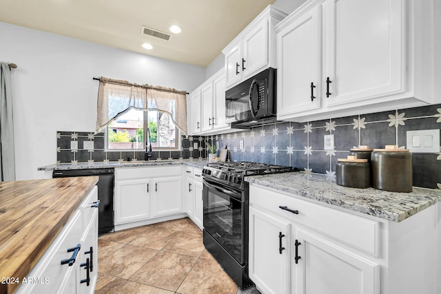 kitchen with wood counters, black appliances, sink, backsplash, and light tile patterned flooring