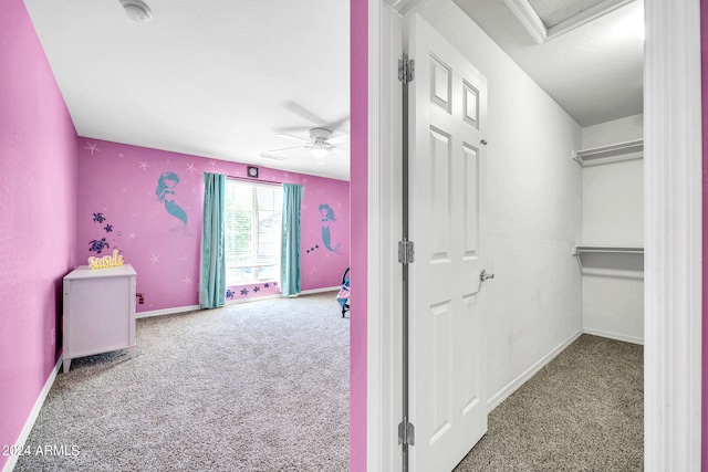 interior space with carpet floors and ceiling fan