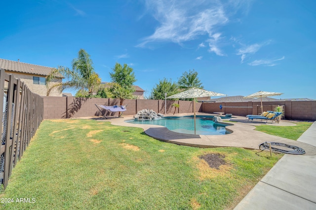 view of swimming pool with a yard and a patio area