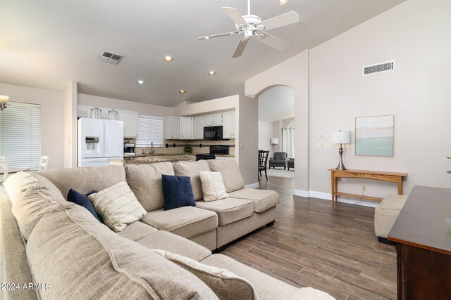 living room featuring dark hardwood / wood-style floors, high vaulted ceiling, sink, and ceiling fan